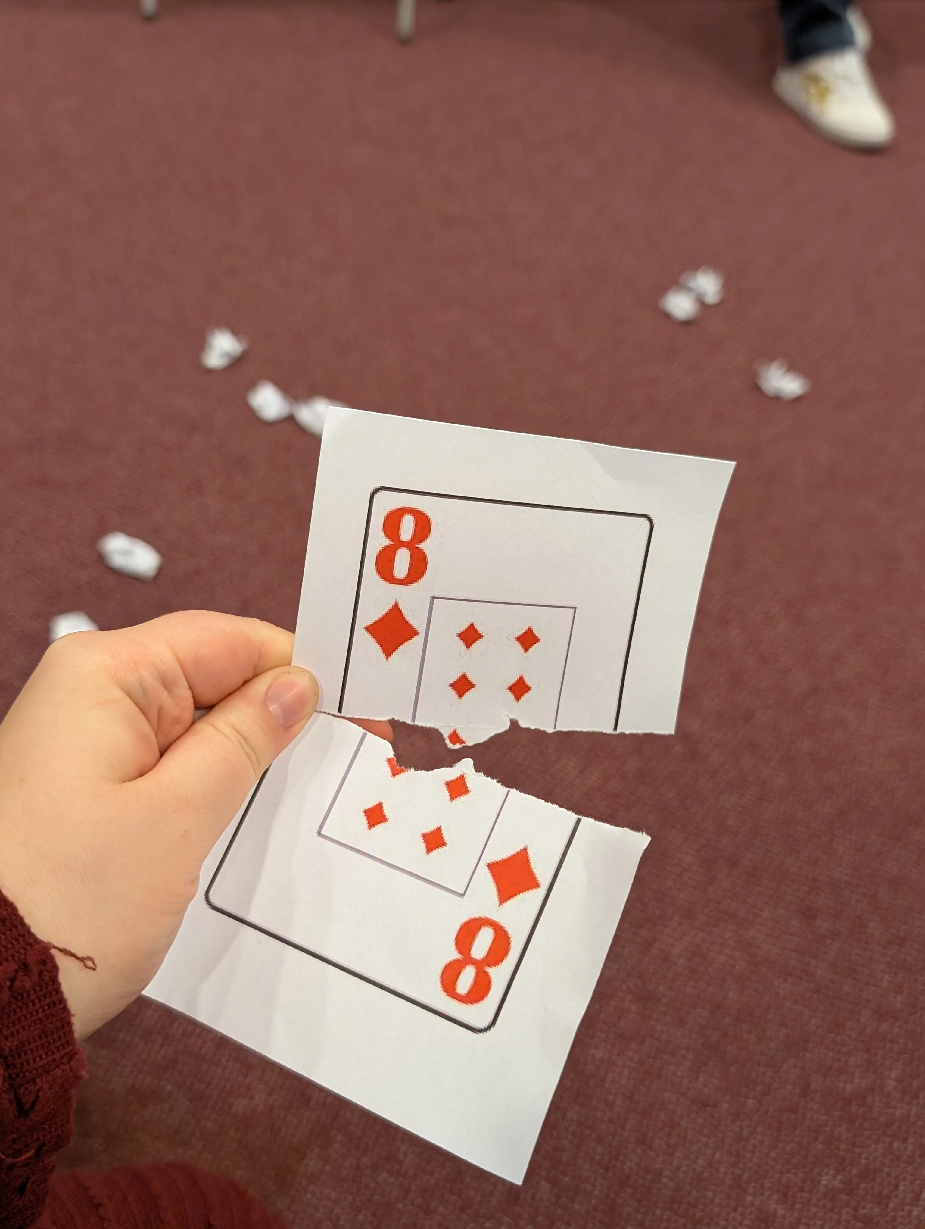 A torn and restored playing card in a guest’s hand